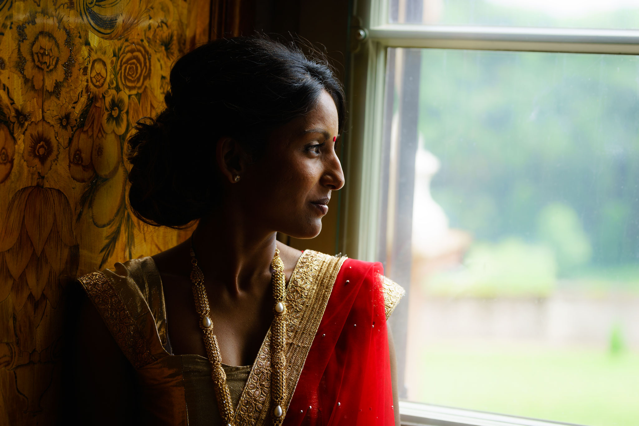 Indische Braut an Fenster mit Hochzeitsfotograf in Trier